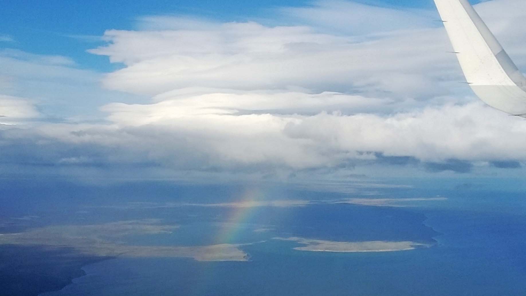 A rainbow-forming shower cloud during descent for Punta Arenas airport